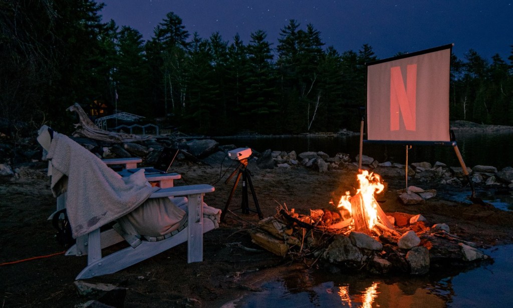 netflix outdoor movie on screen with small projector
