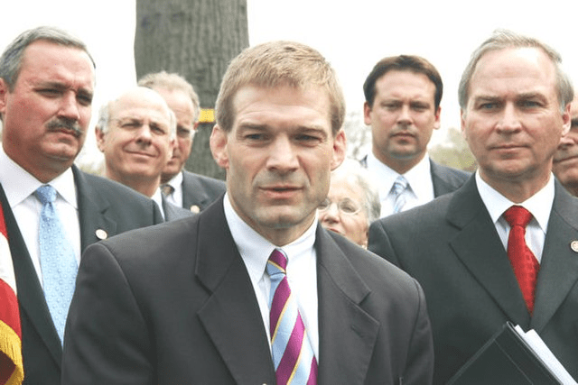 Jim Jordan outside with men standing behind him.