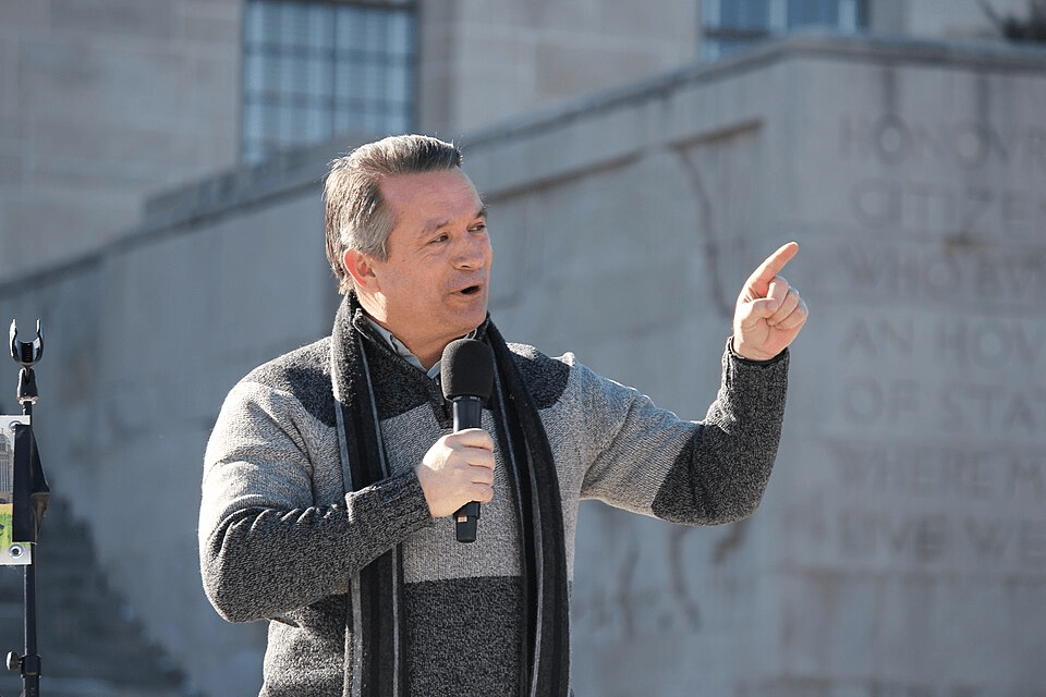 Republican Congressman Don Bacon giving speech outside.
